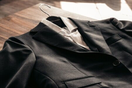 black suit jacket on brown wooden table