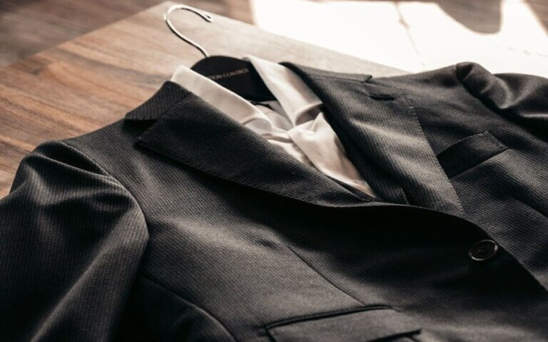 black suit jacket on brown wooden table