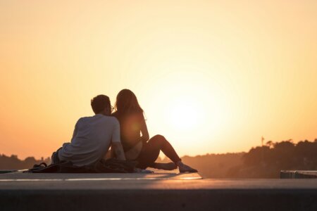 couple sitting near trees during golden hour