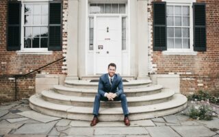 man in blue suit sitting on brown concrete stairs