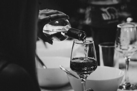 a person pouring wine into a wine glass