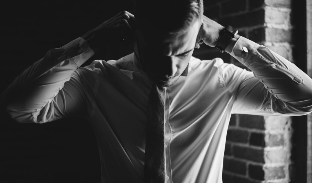 grayscale photo of man dressing up
