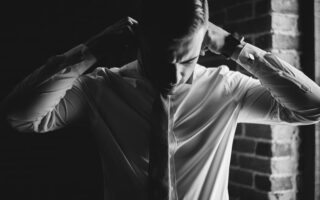 grayscale photo of man dressing up