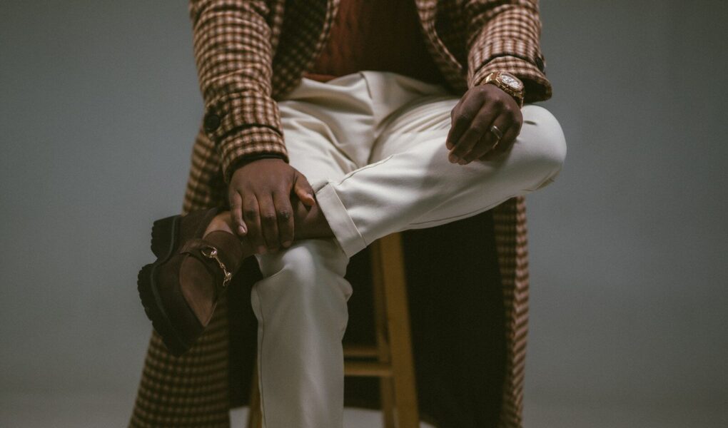 A man in stylish, cozy apparel poses.